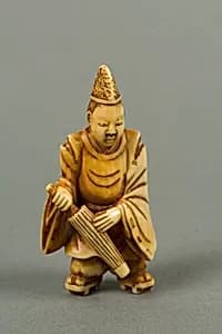 Netsuke of a Boy Carrying an Umbrella by Unknown Artist