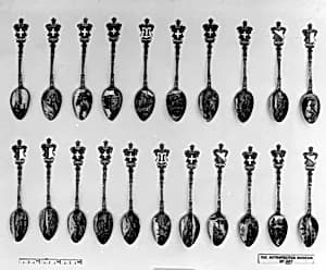 Souvenir spoon with a view of a town with hillside and lake beyond and arms of Switzerland by Unknown Artist
