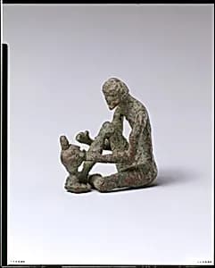 Bronze armorer working on a helmet by Unknown Artist