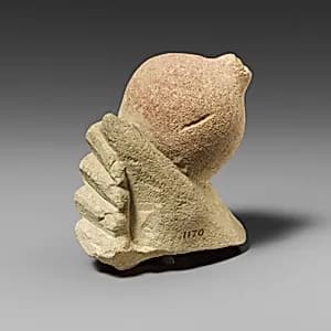 Limestone hand holding a pomegranate by Unknown Artist