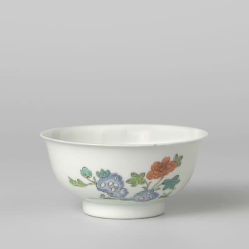 Bell-shaped bowl with flower sprays and a flowering plant near a rock by anonymous