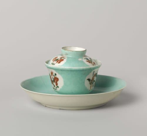 Bell-shaped covered cup and saucer with flowering plants in shaped panels by anonymous