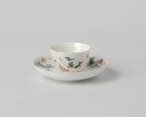 Cup and saucer with lozenges and flowering plants by anonymous