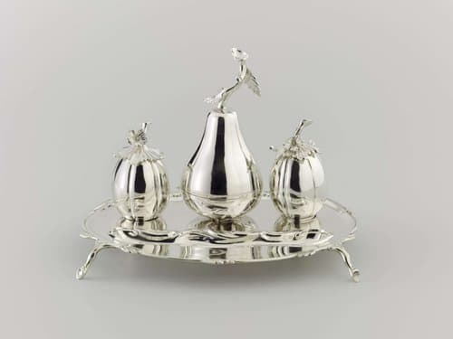 Inktstel van zilver. Blad met uitgebogen voorzijde; inktpot en zandstrooier meloenvormig, tafelbel peervormig
