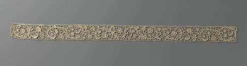 Strook naaldkant met bloemen en bladeren aan voluutranken by anonymous
