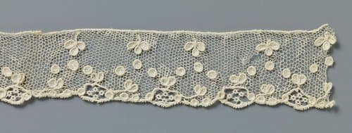 Strook naaldkant met moesjesmotieven by anonymous