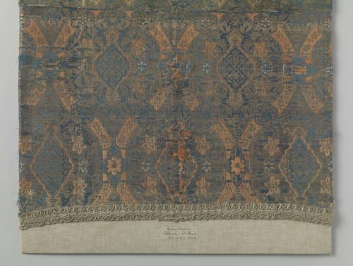 Fragment zijdelampas met een patroon van onder meer granaatappels, bloemranken en geometrische motieven by anonymous