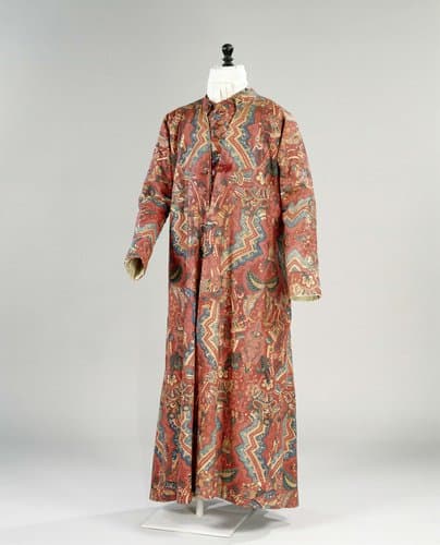 Lang mouwloos vest van sits met een rood fond, versierd met gekleurde zigzagranden, omgeven door abstracte florale motieven; voering en rug van linnen by anonymous