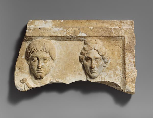 Top of a marble funerary relief with portrait busts of a young man and an elderly woman